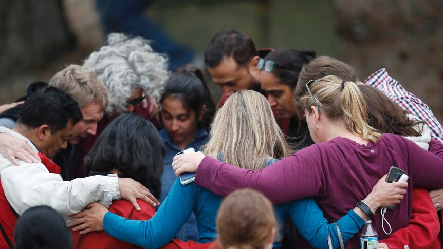 Parents gather in a circle to pray after a school shooting in Colorado.