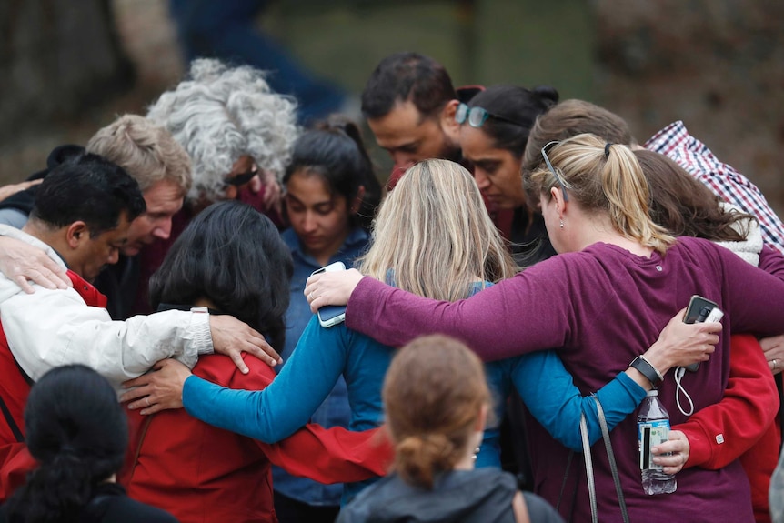 Parents gather in a circle to pray after a school shooting in Colorado.