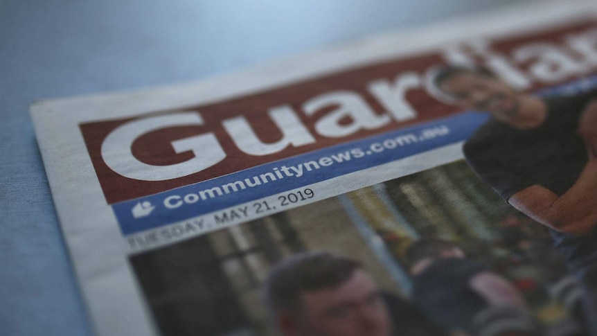 A close up shot of a newspaper with the title "Guardian" in focus.