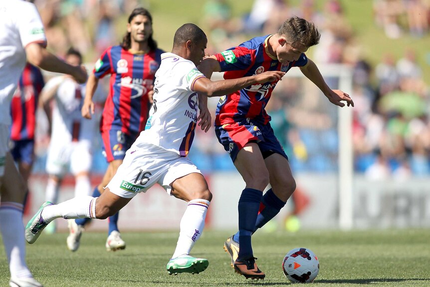 Sidnei Scola Moraes of the Glory tackles Craig Goodwin of the Jets at Hunter Stadium.