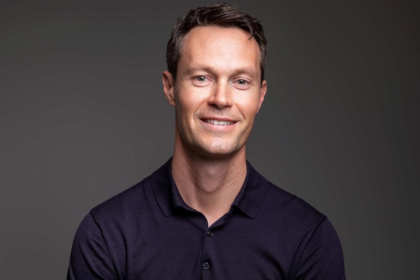 Headshot of a man in a black shirt.