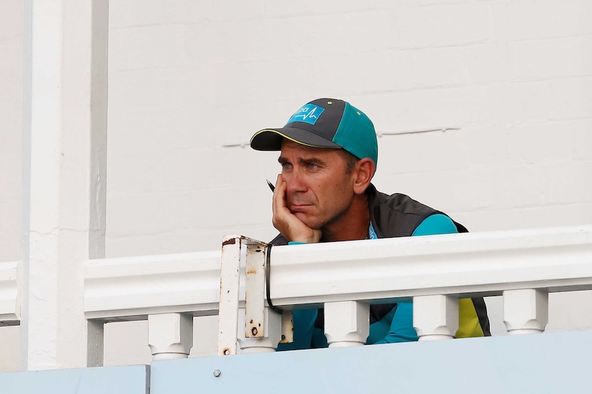 Dejected Australia coach Justin Langer watches the match
