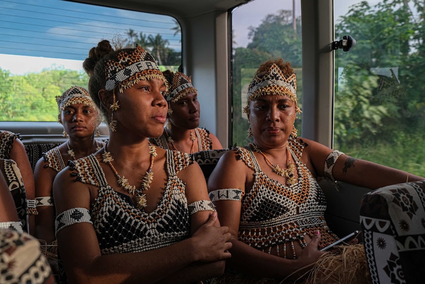 Four of the Faeni dancers sitting in the bus, heading for their final dress rehearsal in the Solomons.