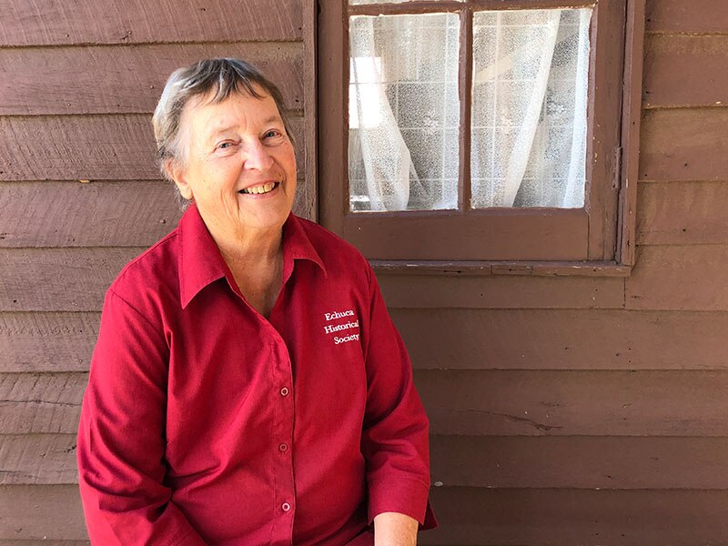 Lady in  red shirt smiling at camera