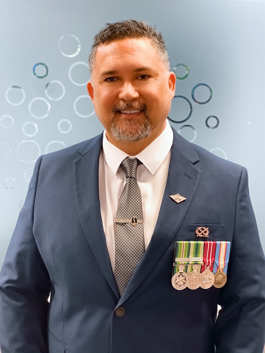 Portrait of proud man wearing medals and blue suit.
