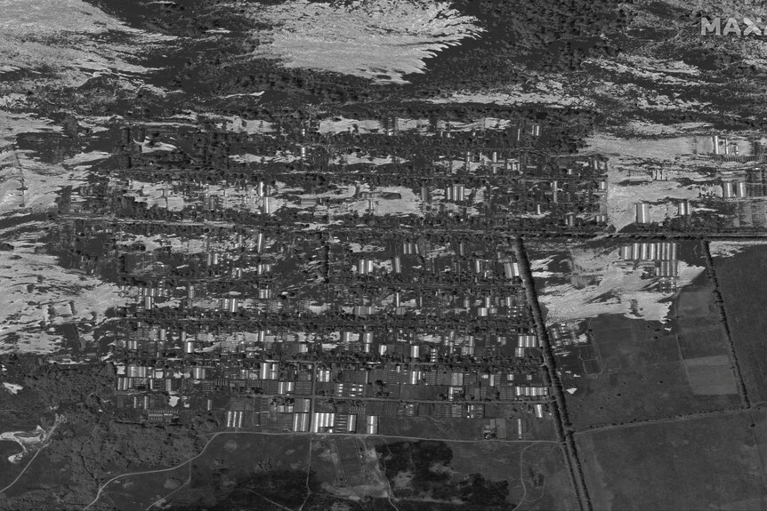 A black and white image shows large swathes of the area covered in water. 
