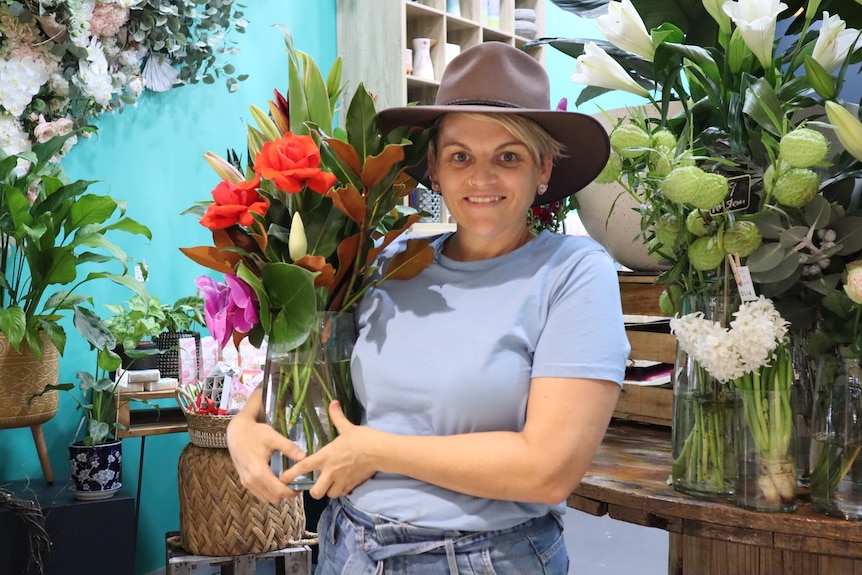 Darwin florist Samantha Perry holds a bouquet of flowers inside her shop.