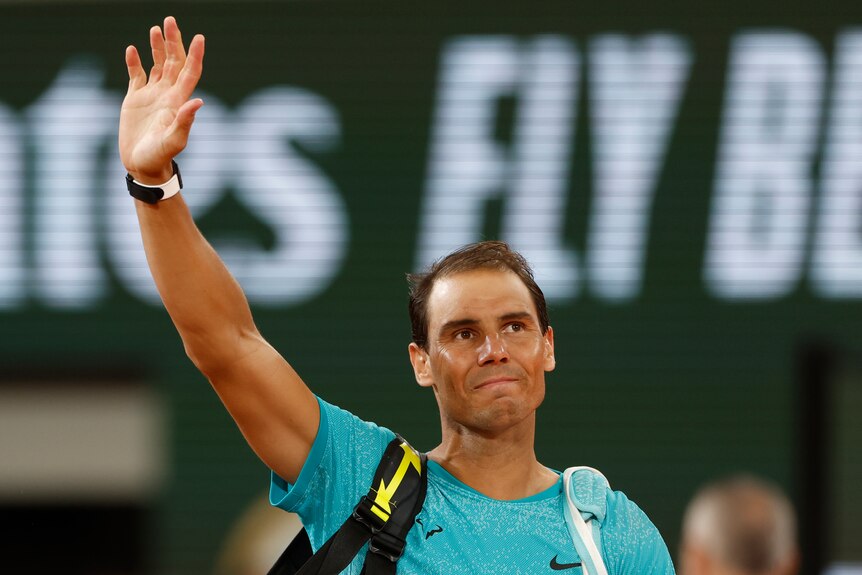 Rafael Nadal waves goodbye to fans on the court at Roland Garros.