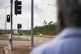 the back of a man's head with traffic lights in the background