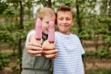 Two children hold purple icy poles