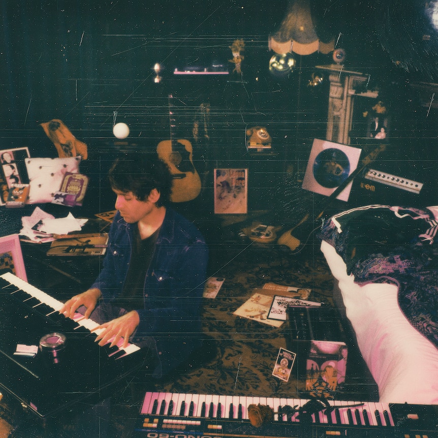 paolo nutini sits in a messy music studio playing the keyboard