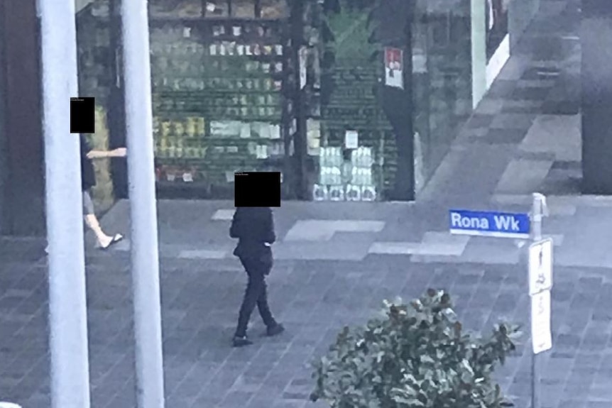 Screenshot of a footage showing someone walking towards a convenience store.