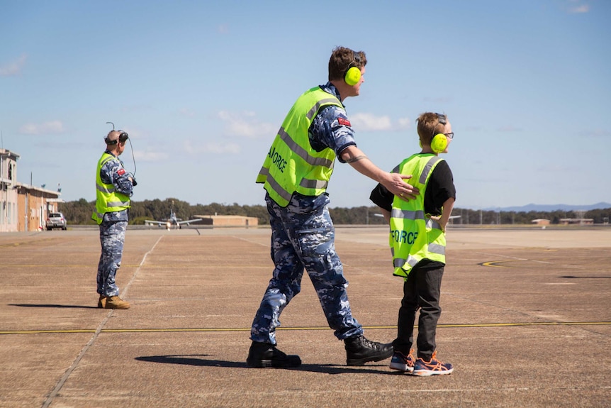 Trevor Connell walks with Finn Coker on the tarmac.