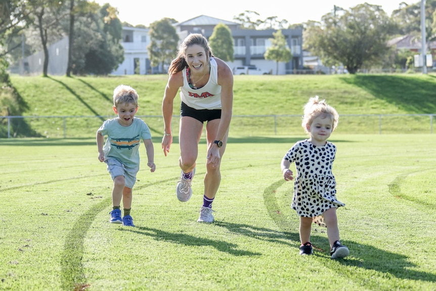 Amy O'Halloran runs and plays with her kids Henry (3) and Jemima (1) on an oval.