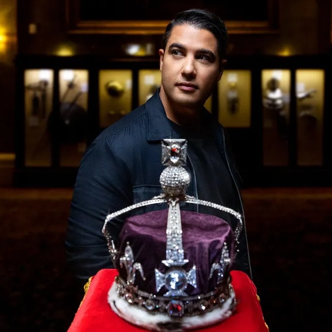 Marc Fennell stands next to the British Crown Jewels.