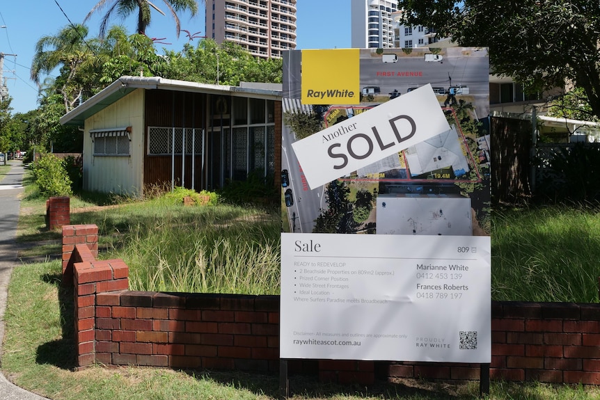 sign in front of old house that reads sold