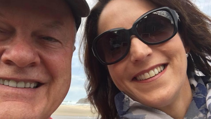 A selfie of Rob Vigors and Karen Ridge, who is wearing sunglasses, on a beach smiling.