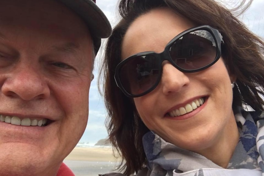 A selfie of Rob Vigors and Karen Ridge, who is wearing sunglasses, on a beach smiling.