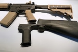 Picture of a bump stock next to a semi-automatic assault rifle