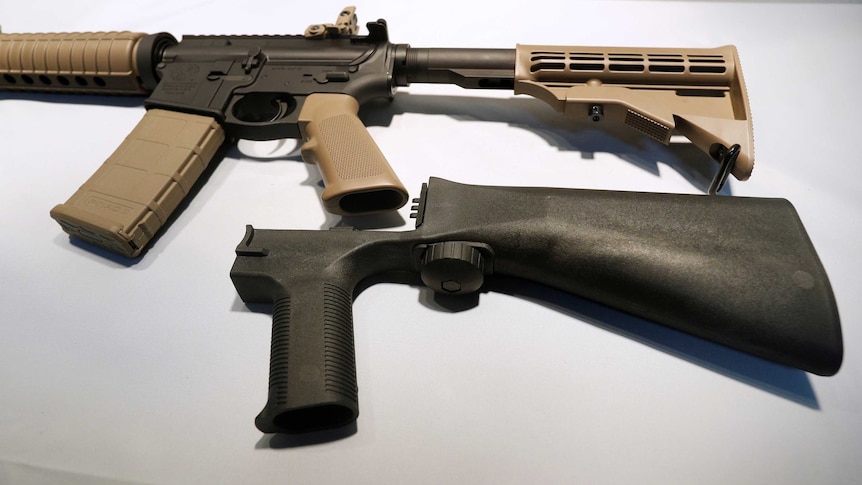 Picture of a bump stock next to a semi-automatic assault rifle