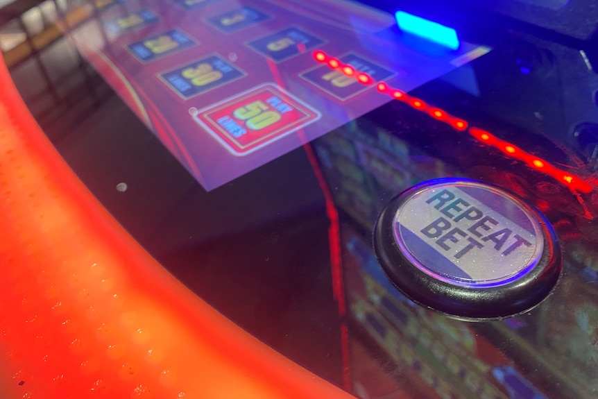 A close up photo of a 'Repeat Bet'' button on a pokies machine