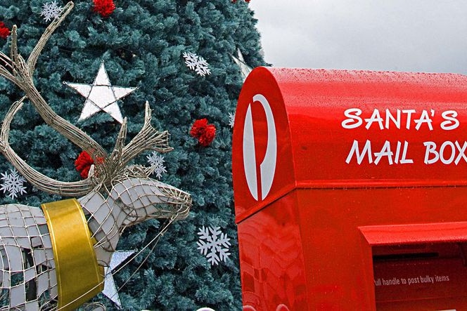 An Australia Post mail box next to a reindeer and Christmas tree