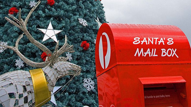 An Australia Post mail box next to a reindeer and Christmas tree