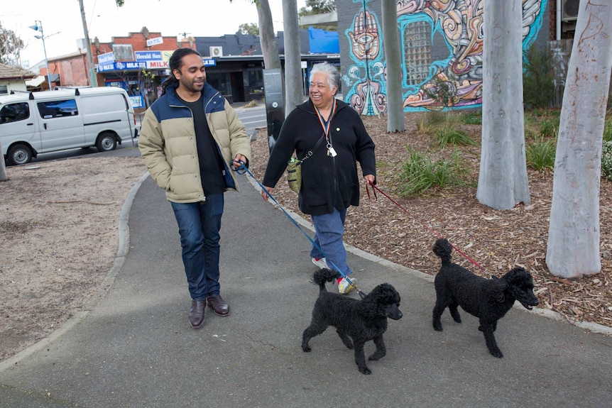 Scott and Maggie smile as they walk her black poodles.