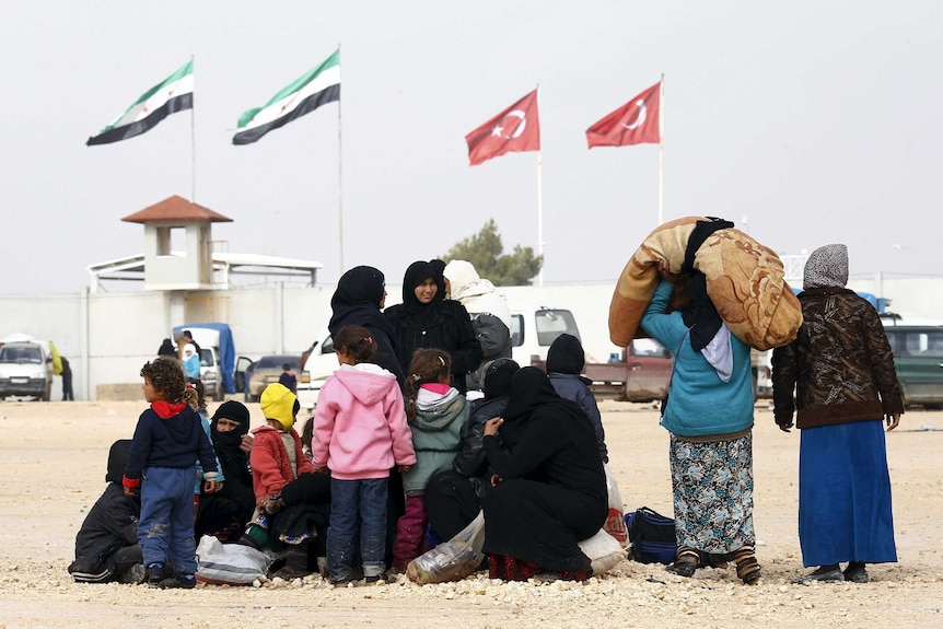 Displaced Syrians wait near border crossing to Turkey