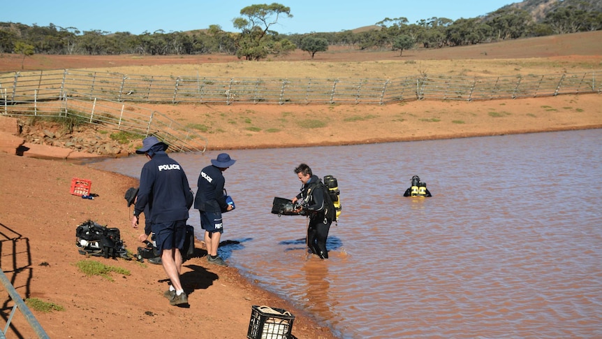 Police divers search a dam on a rural property.