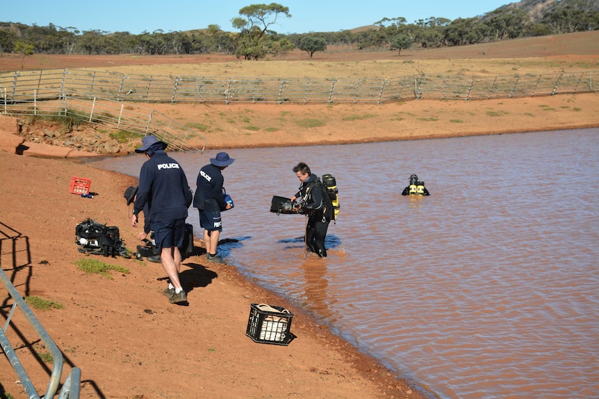Police divers search a dam on a rural property.