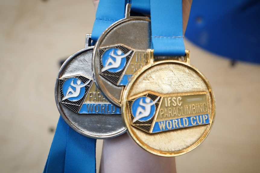 Australian paraclimber Sarah Larcombe holds medals won at ISFC World Cup.