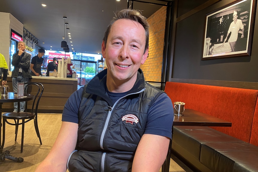 A man in a bakery smiling 