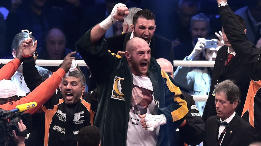 Tyson Fury (C) celebrates after beating Wladimir Klitschko to win world heavyweight boxing title.