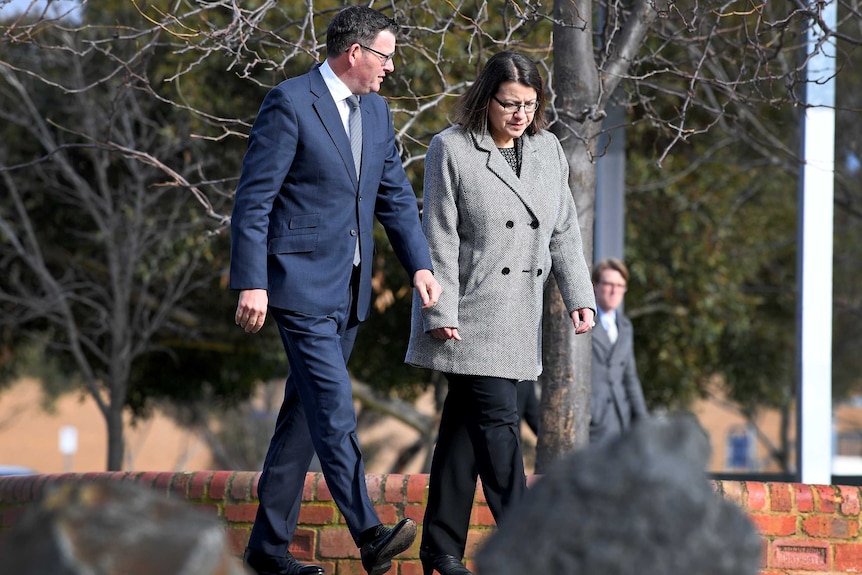 Jenny Mikakos walks alongside Dan Andrews on an outdoor path, surrounded by trees.