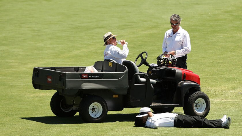 Umpire Asad Rauf takes a breather during a drinks break on day two.