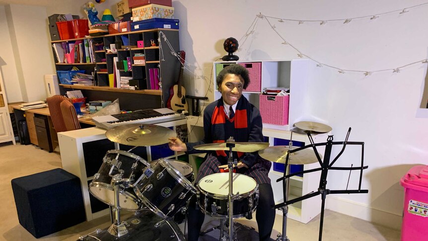 Emai on the drums in her room.