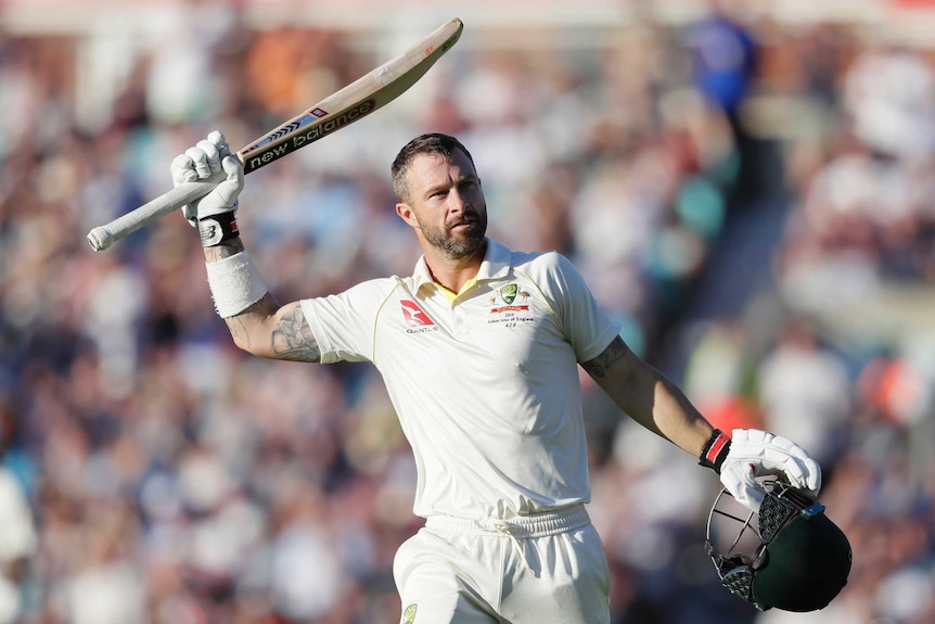 Australia batsman Matthew Wade lifts his bat above his head and holds his helmet in his other hand after reaching a Test century