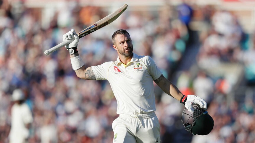 Australia batsman Matthew Wade lifts his bat above his head and holds his helmet in his other hand after reaching a Test century