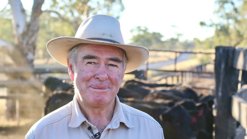 Man in a hat in a rural setting.