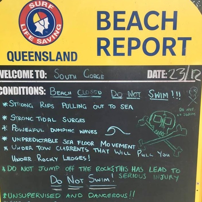 A chalk board sign stands at a beach with information about the conditions there.