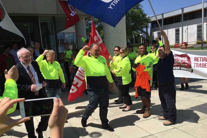 John Lomax celebrates outside the ACT Magistrates Court