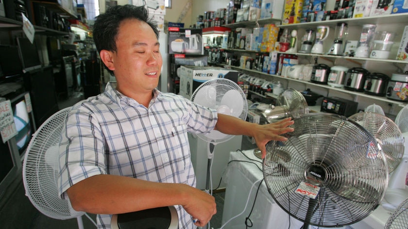 Alan Ly tries to cool himself in a electrical appliance shop in Collingwood