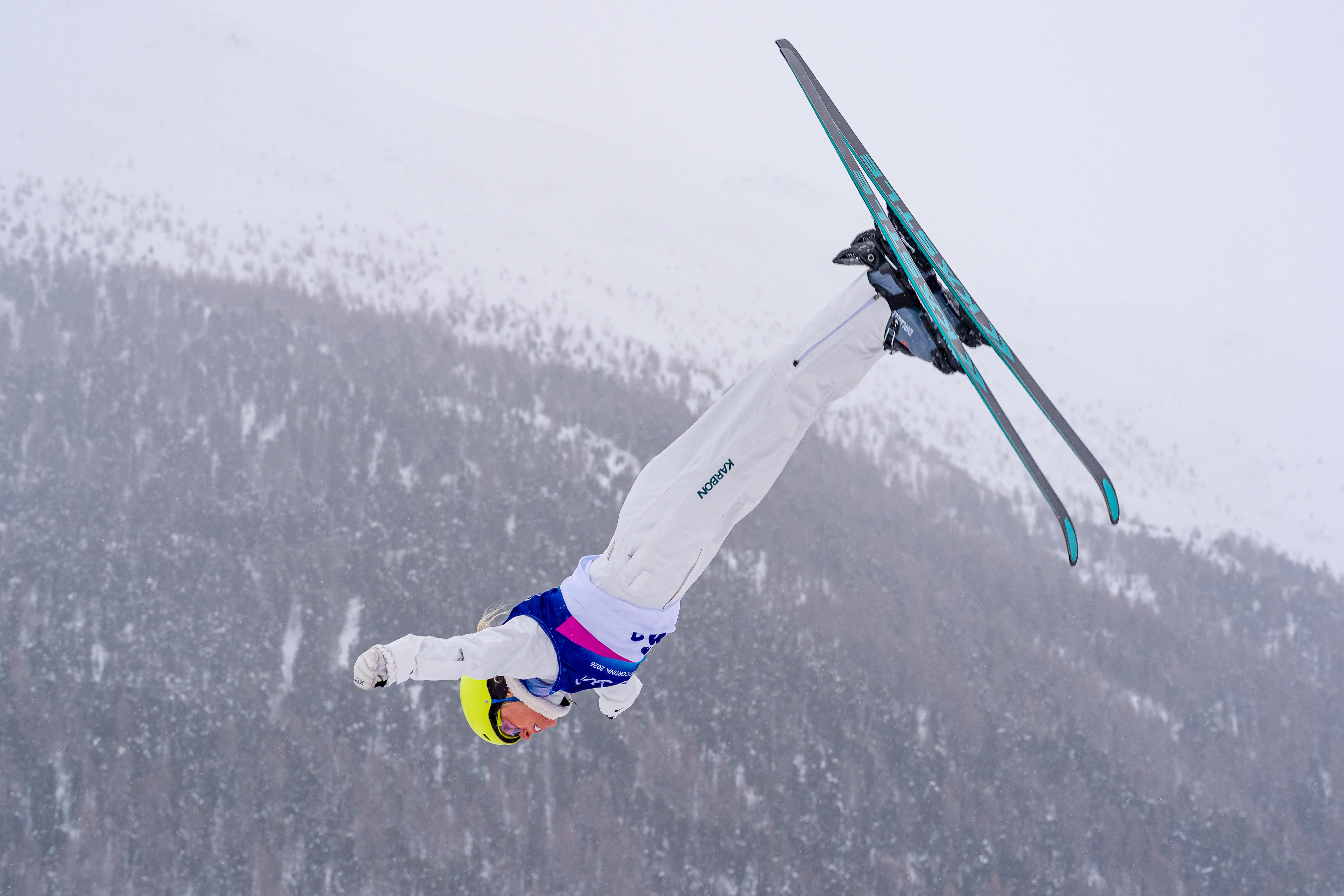 Dani Scott leaps in the air with forest in the background