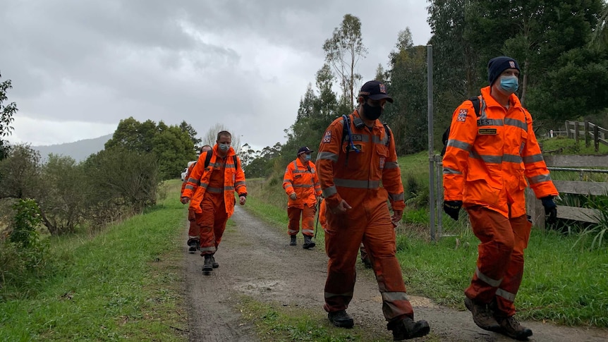A group of SES volunteers walk along a trail.