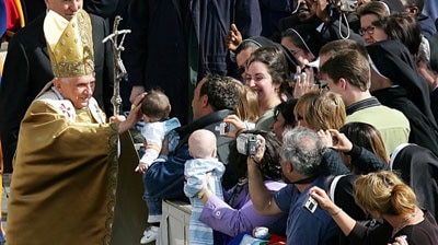 Pope Benedict XVI blesses a baby as he arrives to lead the Easter mass