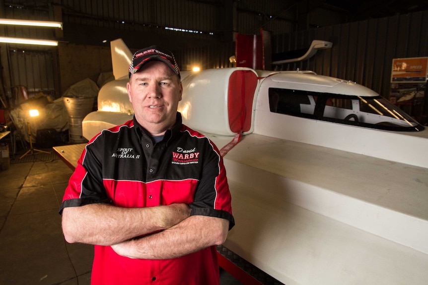 Ken Warby stands next to his power boat.