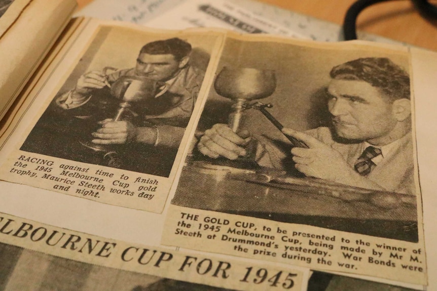 Archival newspaper image in scrapbook of man carving Melbourne Cup