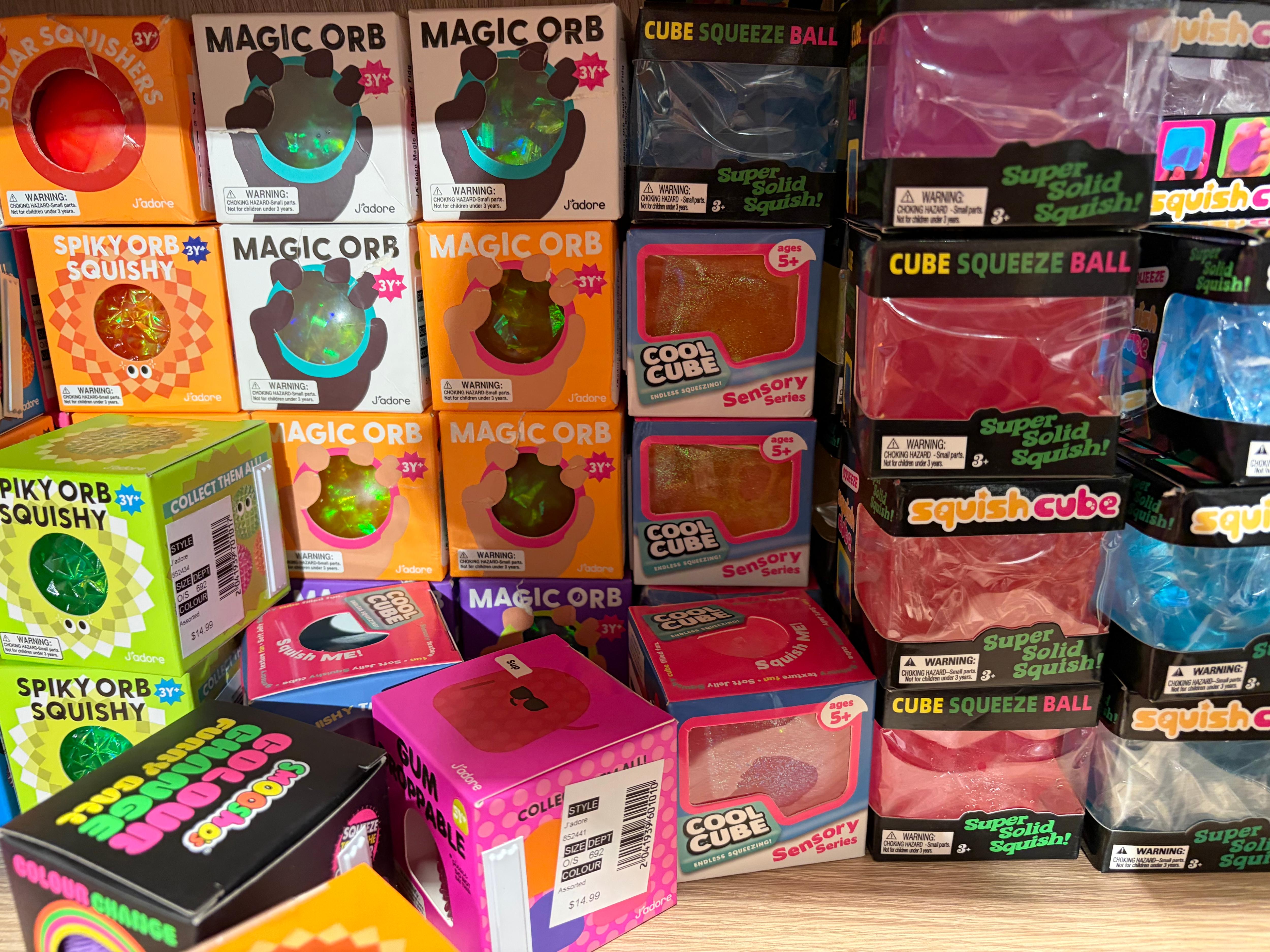 Boxes of small squishy cubes stacked on a store shelf.