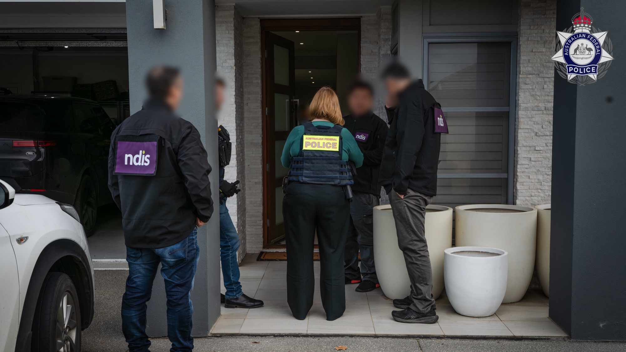 AFP and NDIS investigators outside a home during the Adelaide fraud investigation